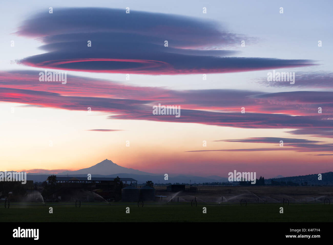 Pink hues are reflected of the clouds over Mount Jefferson Oregon Stock Photo