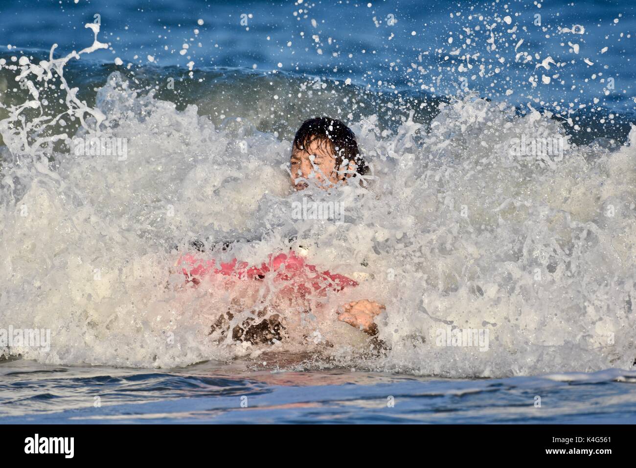 Riding waves with a boogie board at the ocean Stock Photo