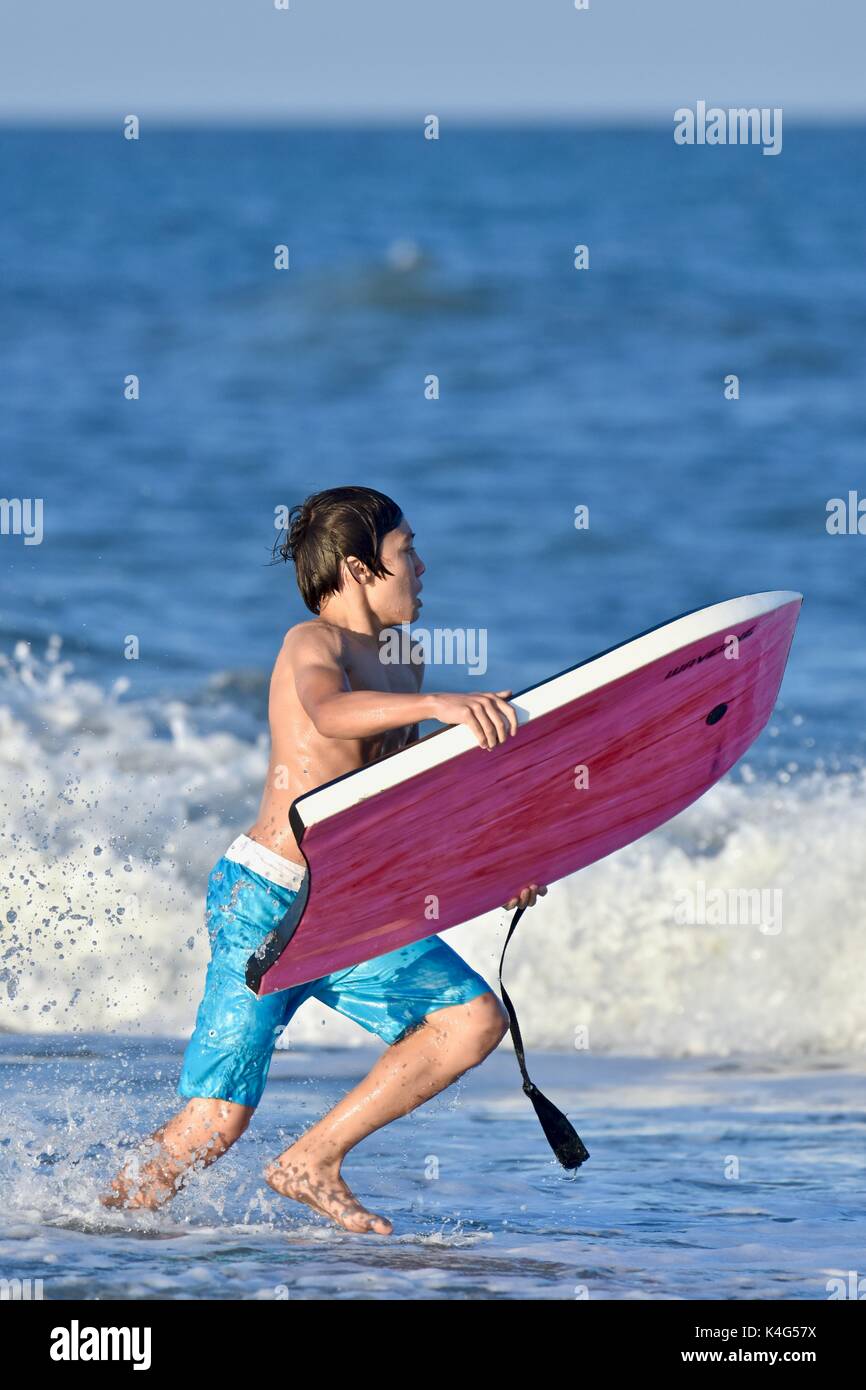 Riding waves with a boogie board at the ocean Stock Photo Alamy