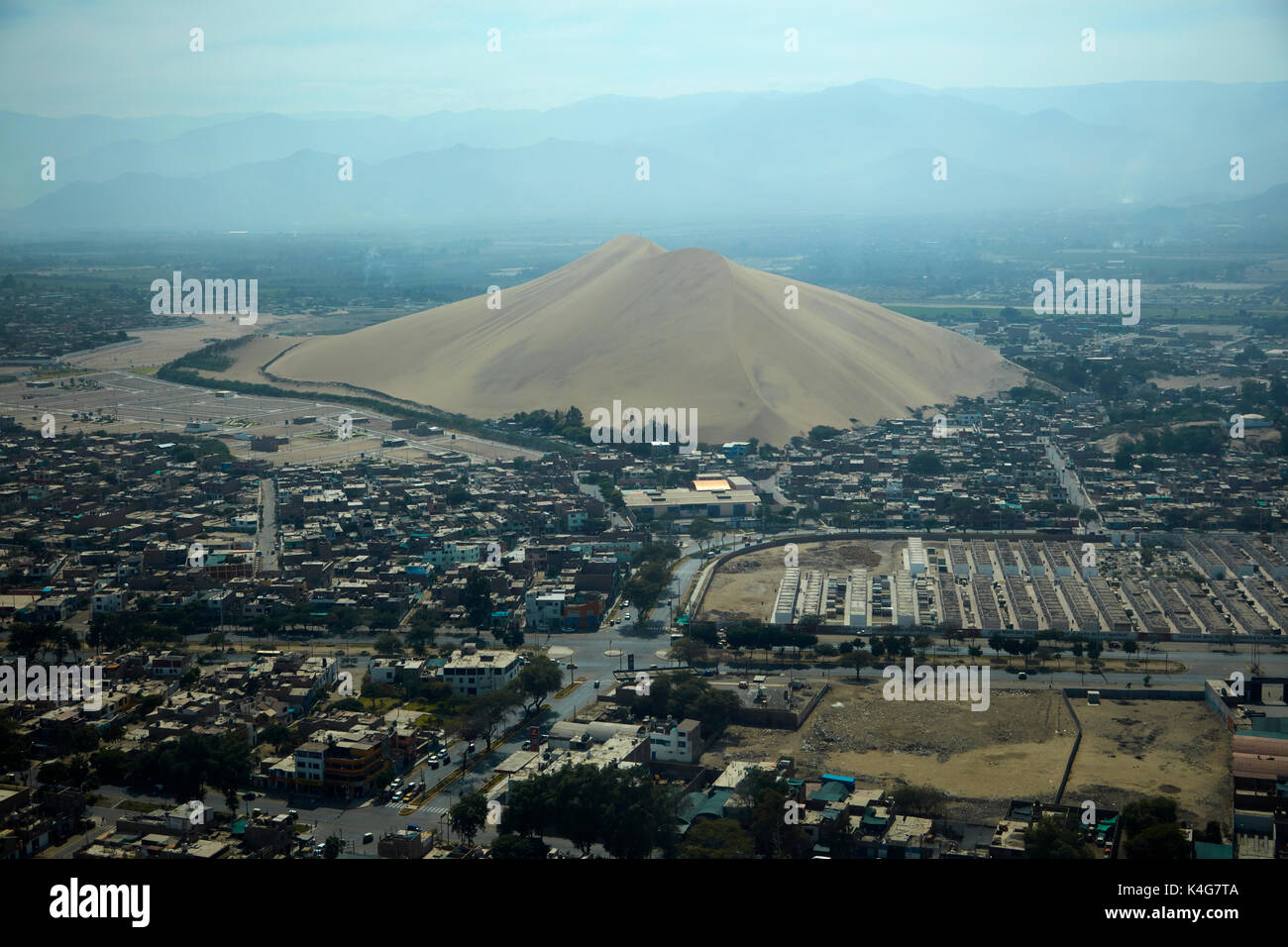 Cerro Saraja, giant sand dune in the middle of Ica City, Peru, South America - aerial Stock Photo
