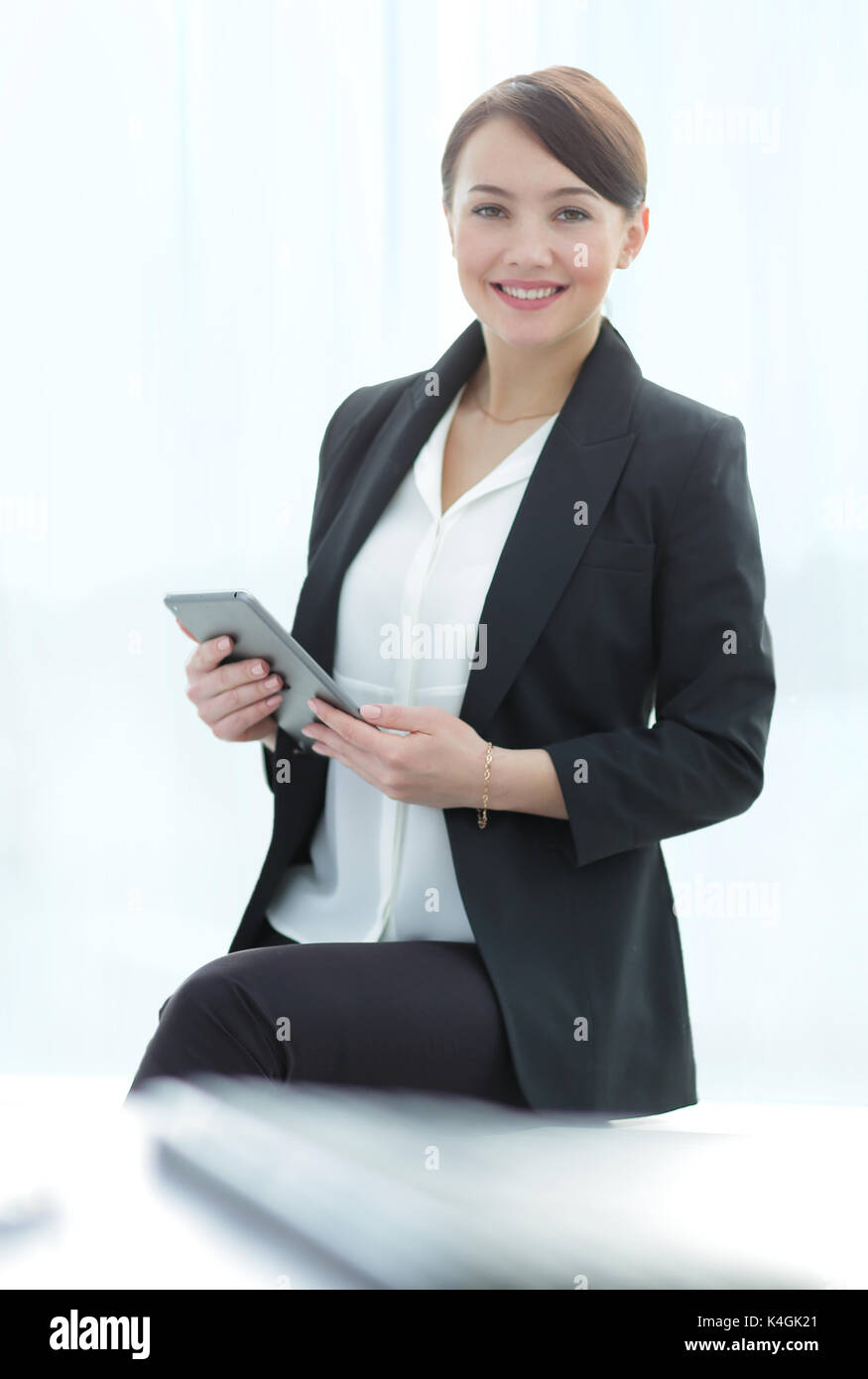 Smiling young businesswoman using laptop in office Stock Photo - Alamy