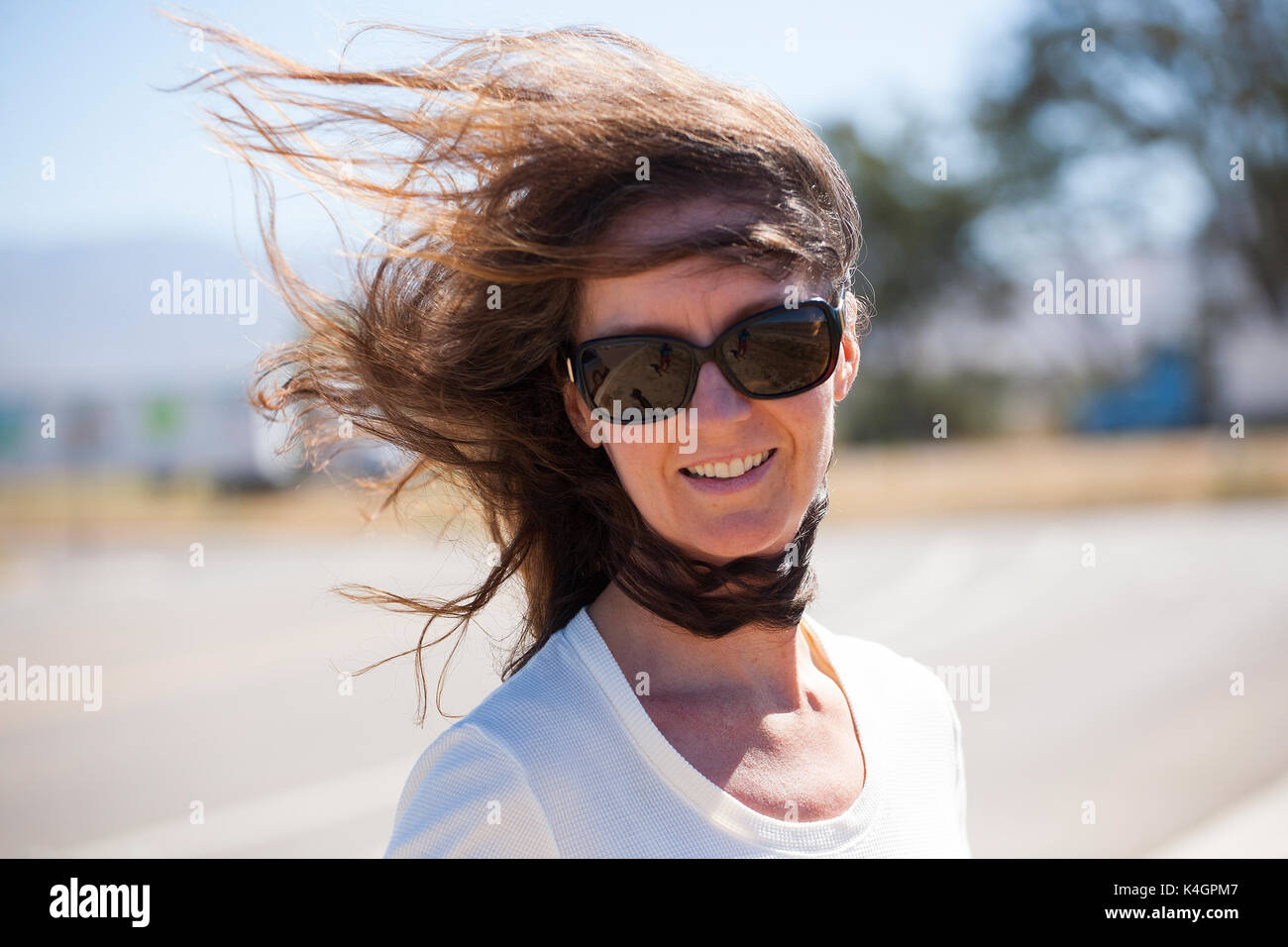 A woman experiences high winds in central California Stock Photo