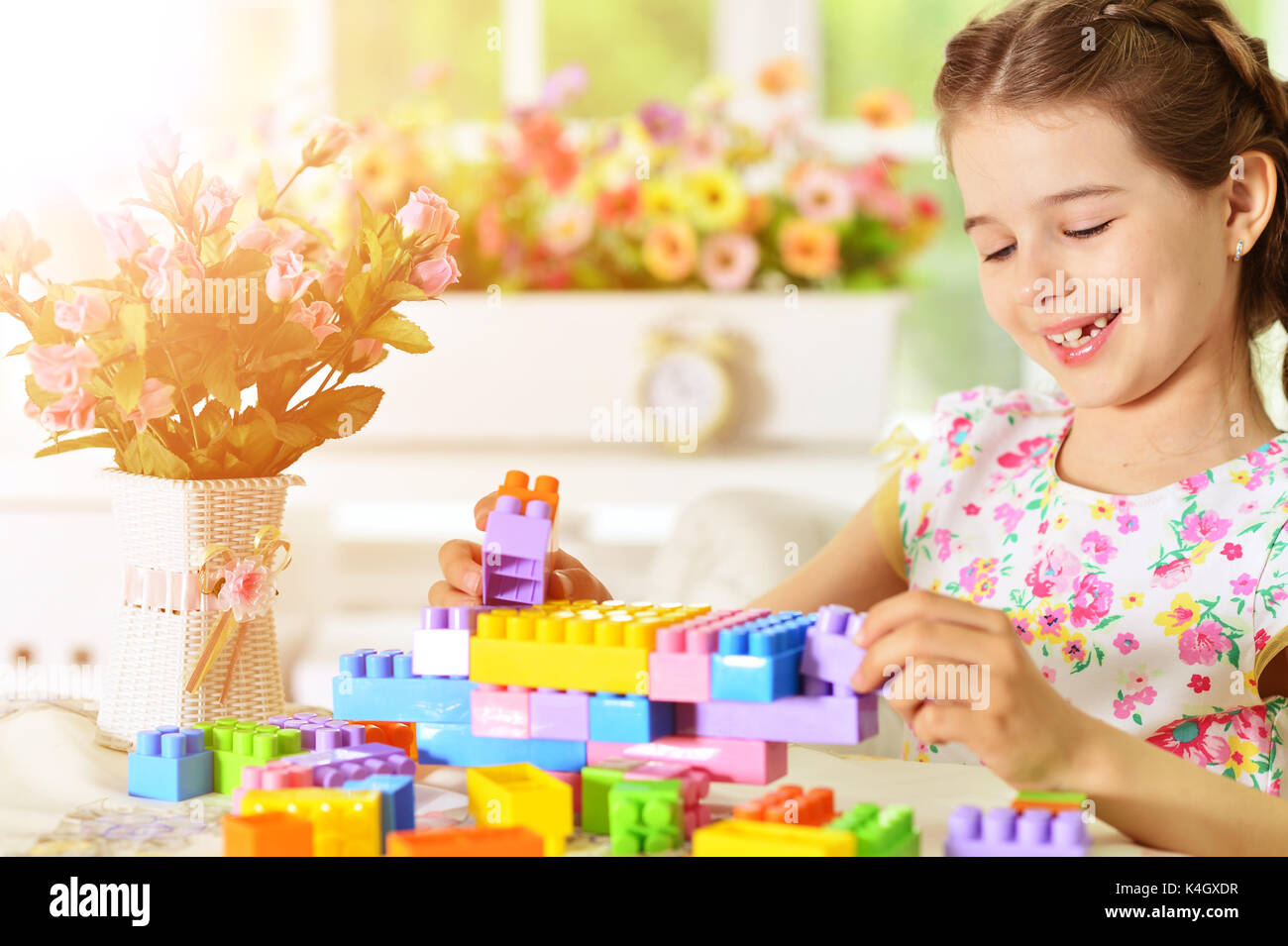 Adorable little girl playing with colorful plastic blocks Stock Photo ...