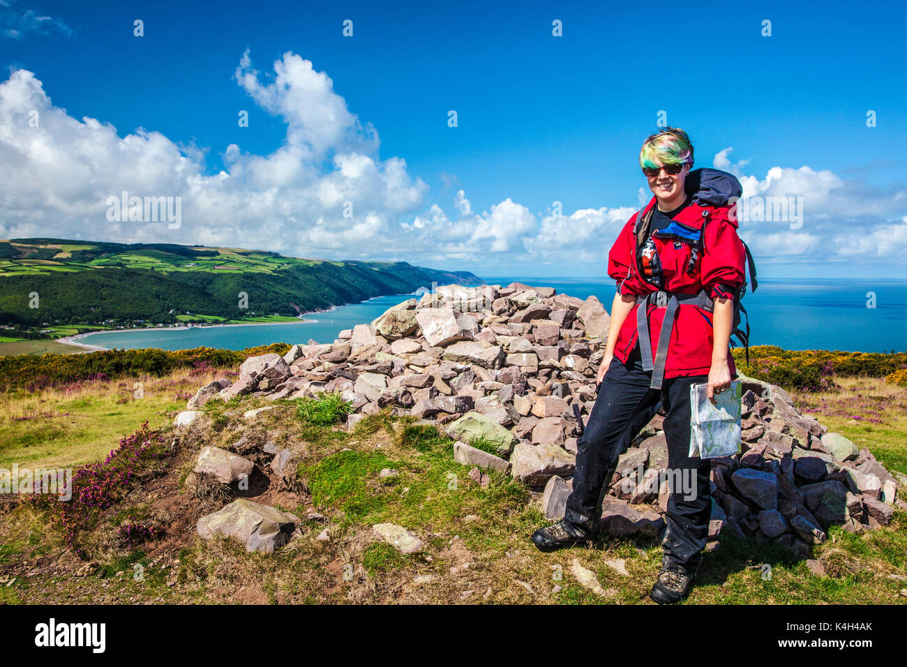 Young walker poses by the stone cairn on Bossington Hill with Porlock Bay in the background. Stock Photo