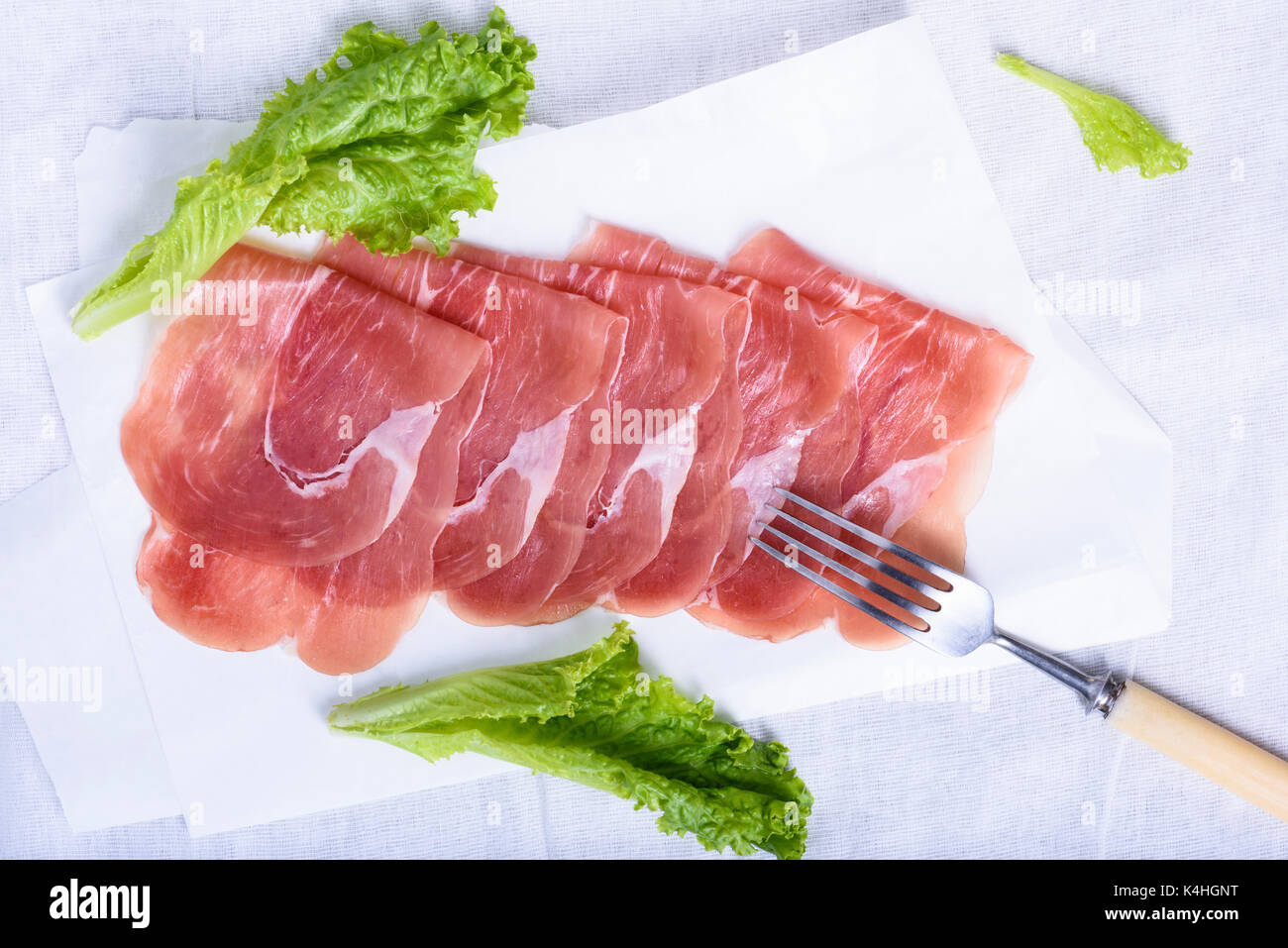 Italian prosciutto, Cured Pork Ham. Sliced meat snack with salad. Above