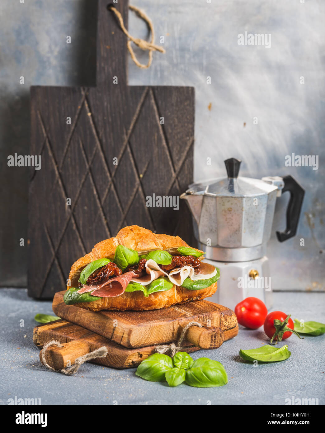 Croissant sandwich with smoked meat Prosciutto di Parma, sun dried