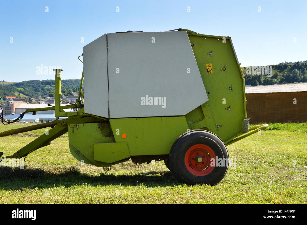 A baler type agricultural equipment, to make straw or hay bales. Stock Photo