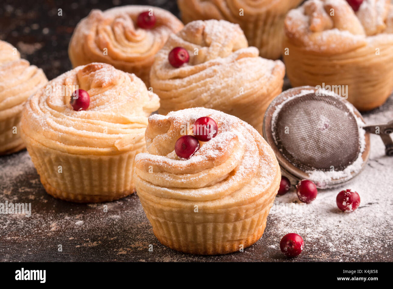 Delicious Cruffins come-together of a flaky Croissant in shape of a Muffin. Morning buns. Muffins on dark background. Stock Photo
