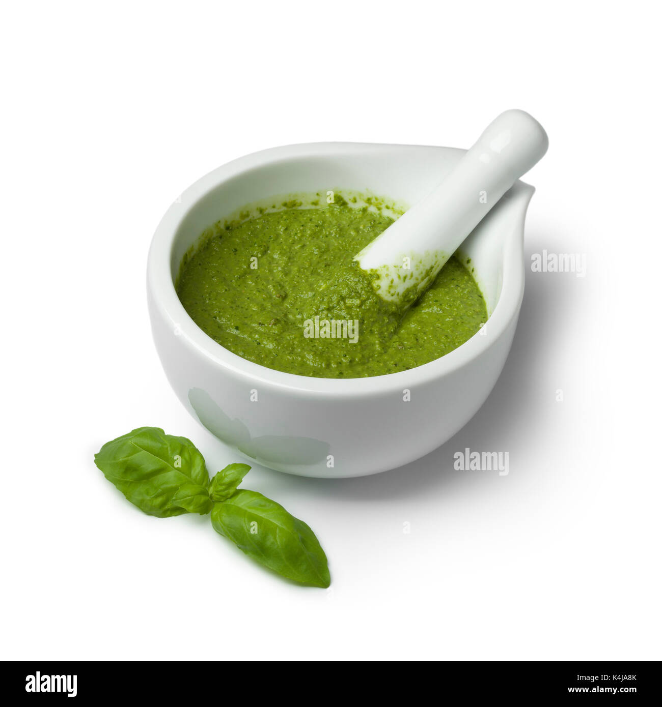 Green homemade Italian pesto in a mortar on white background Stock