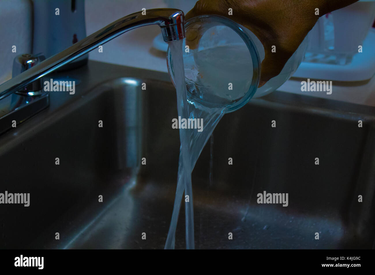 Pouring water down the drain Stock Photo Alamy
