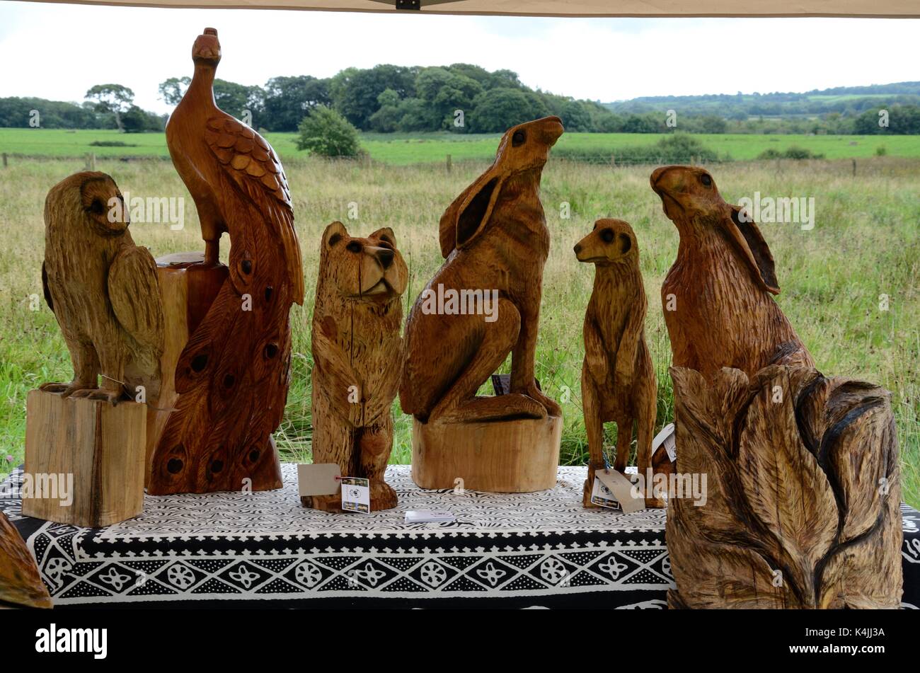 Carved wooden animals for sale at a country fair Pembrokeshire Wales Cumru UK GB Stock Photo