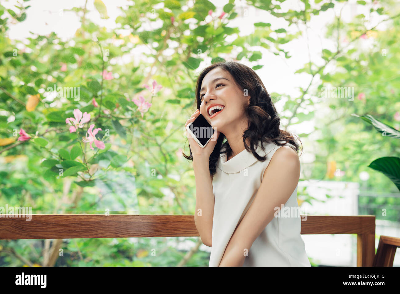 Confident young asian woman in smart casual wear talking to mobile phone Stock Photo