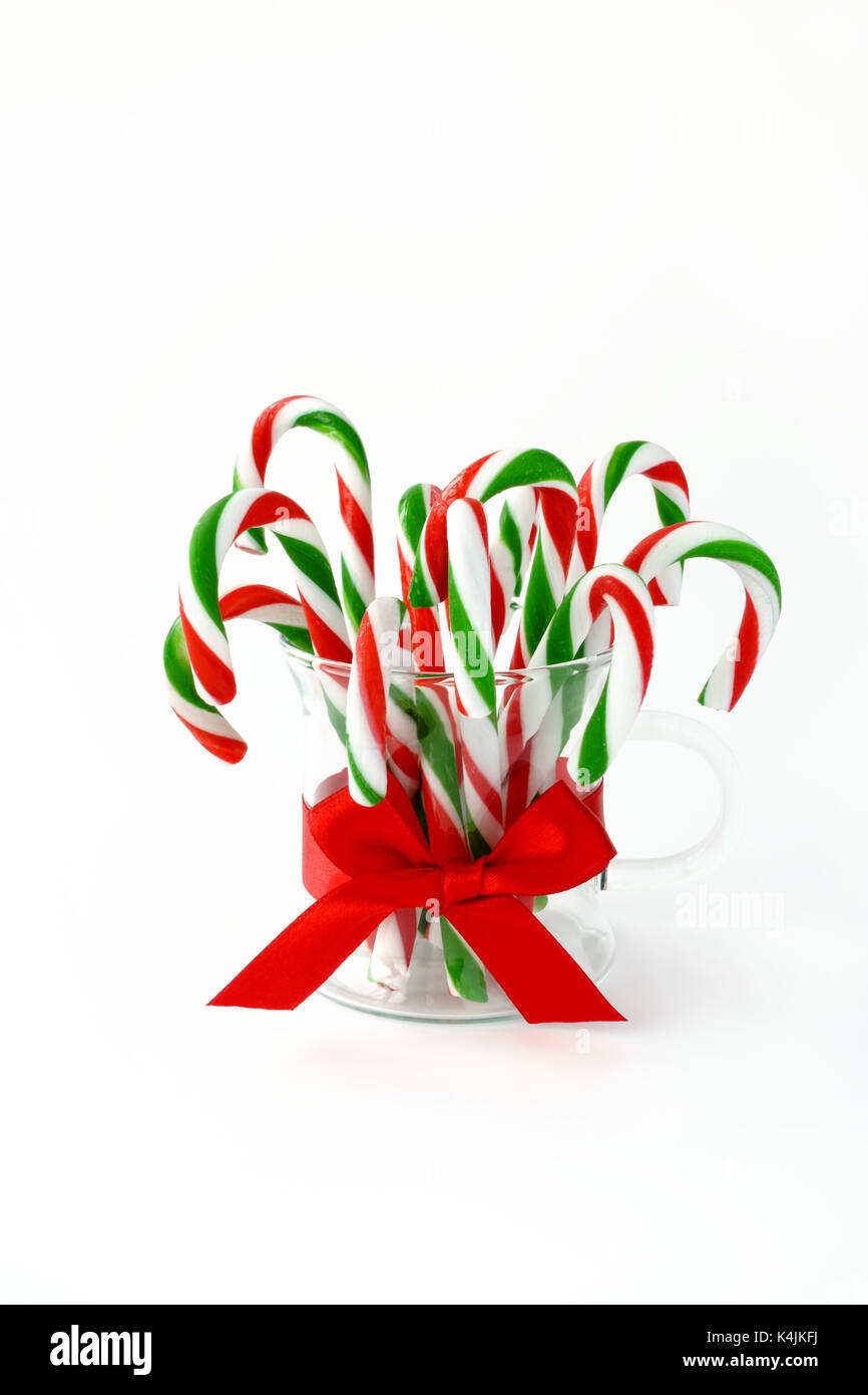 Closeup of red and green striped candy canes in a glass decorated with