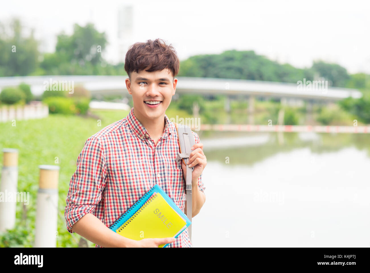 College asian male student holding book on the park Stock Photo