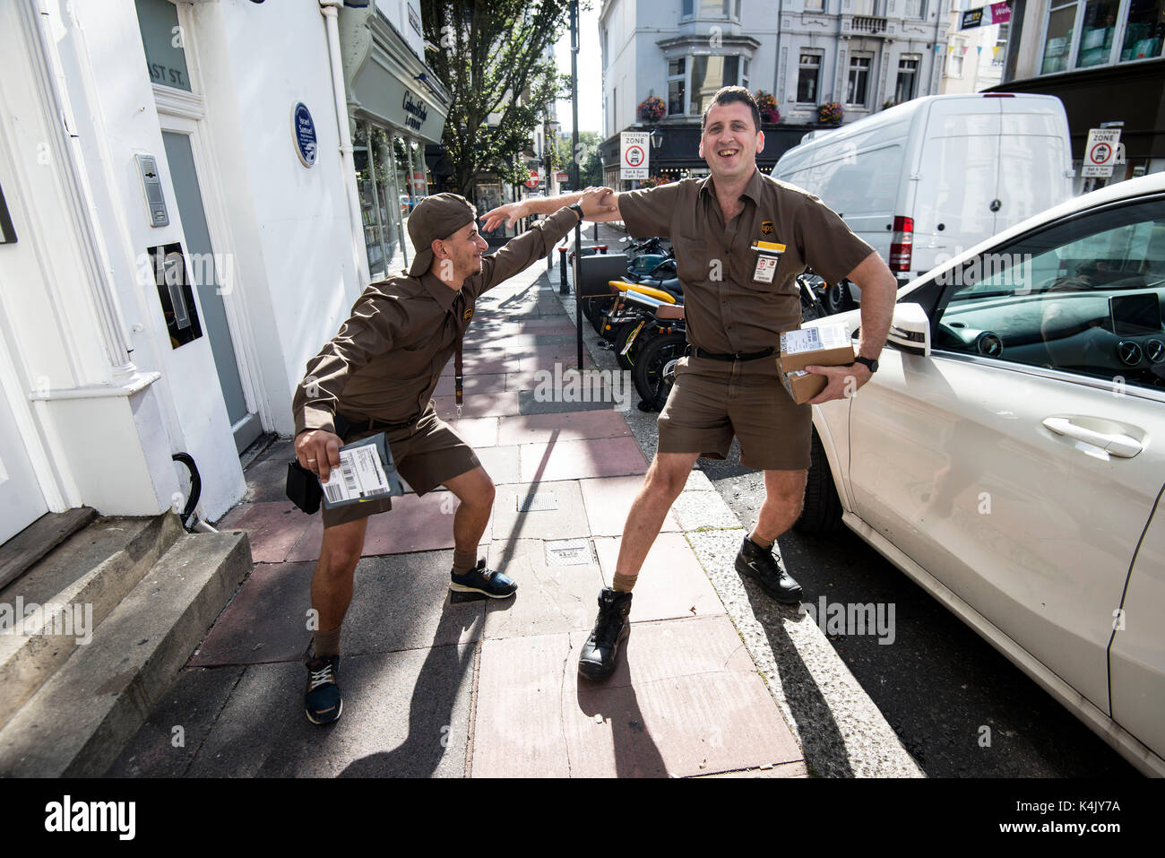 Two UPS couriers in Brighton city centre are happy to spare a moment to pose for a photograph. Credit: Terry Applin Stock Photo