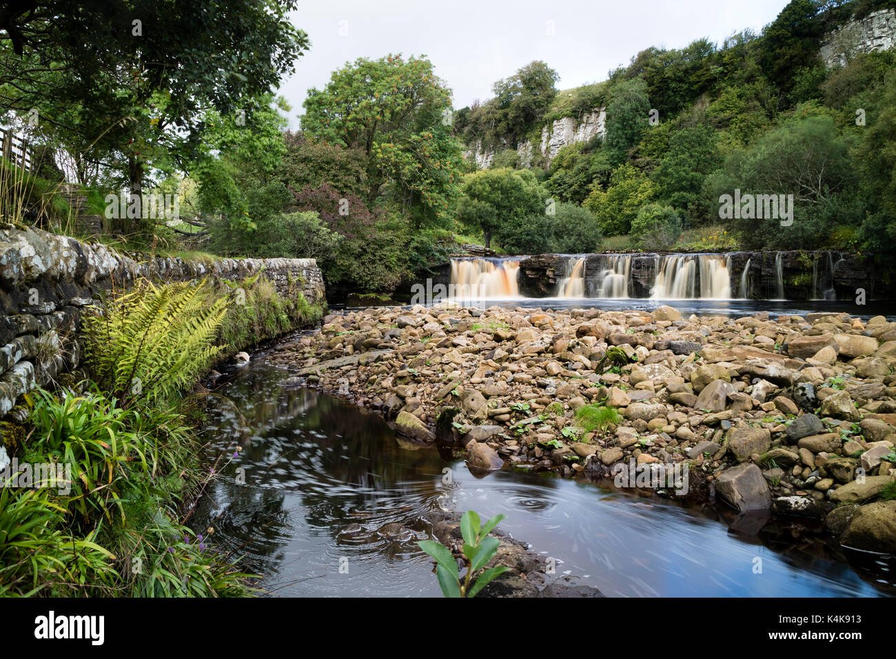 River Swale, Keld, Yorkshire Dales.  Wednesday 6th September 2017. UK Weather.  After a damp start the sun breaks through to illuminate Wain Wath Falls on the River Swale near the village of Keld. Credit: David Forster/Alamy Live News. Stock Photo