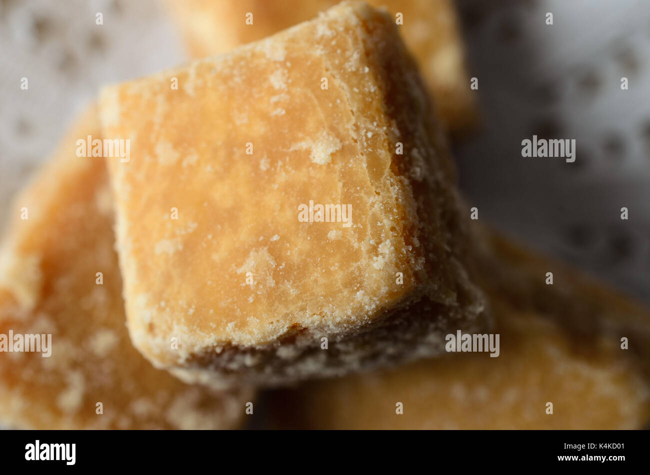 Overhead close up (macro) of hand made fudge pieces on a lacy white paper doily. Stock Photo