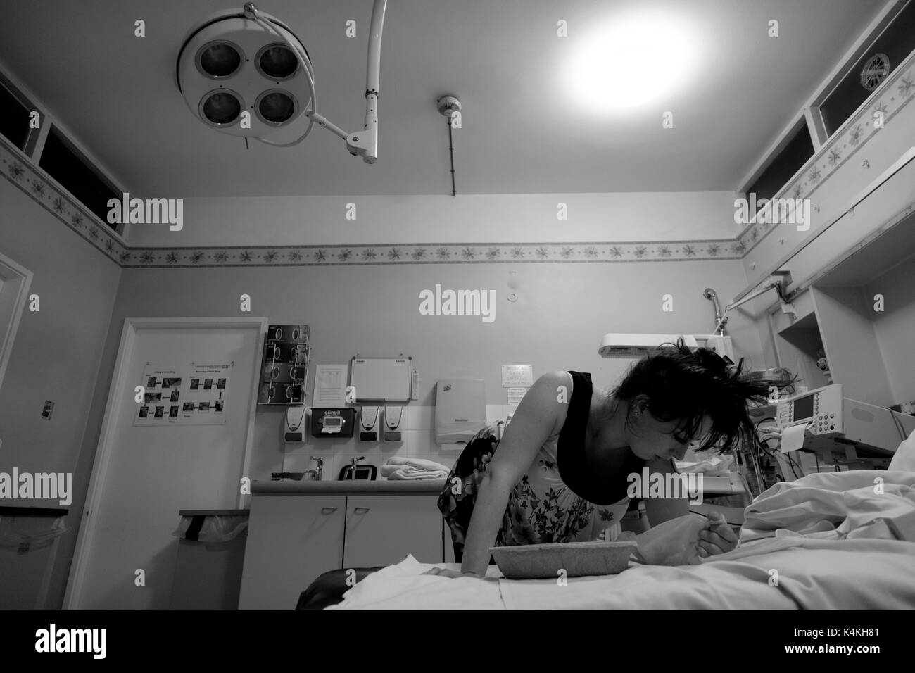 Black and white image of a female about to give birth in Luton and Dunstable Hospitals delivery suite. Credit - Lee Ramsden / ALAMY Stock Photo