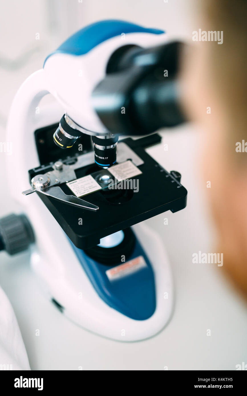 Closeup picture of researcher looking through microscope Stock Photo