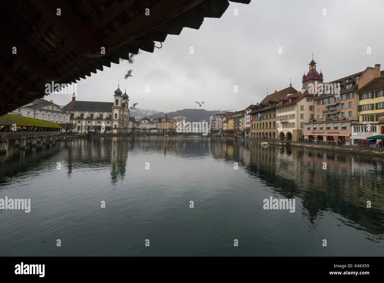 View of Jesuit Church and typical buildings from Chapel Bridge on river Reuss Rathausquai Lucerne Switzerland Europe Stock Photo