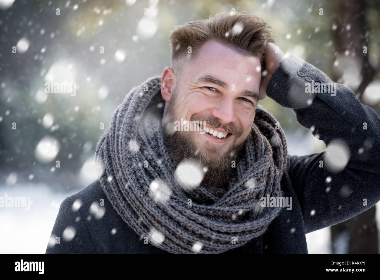 Smiling man in snowing forest Stock Photo