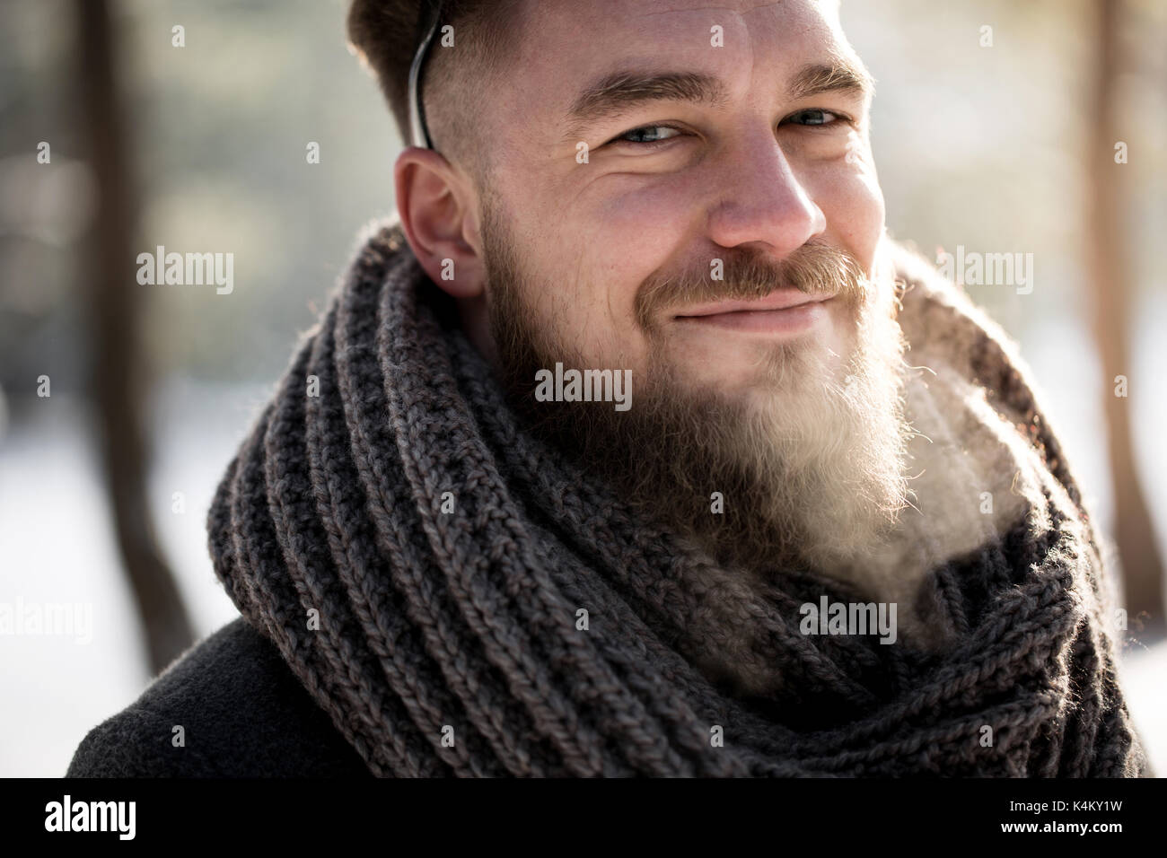 Cheerful handsome man walking in winter forest Stock Photo