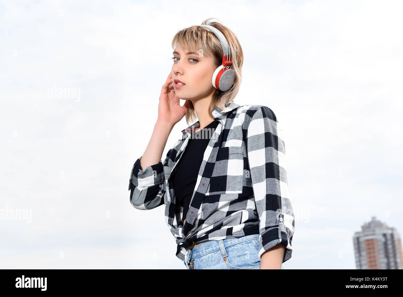 pensive caucasian girl listening music in headphones and looking at camera Stock Photo