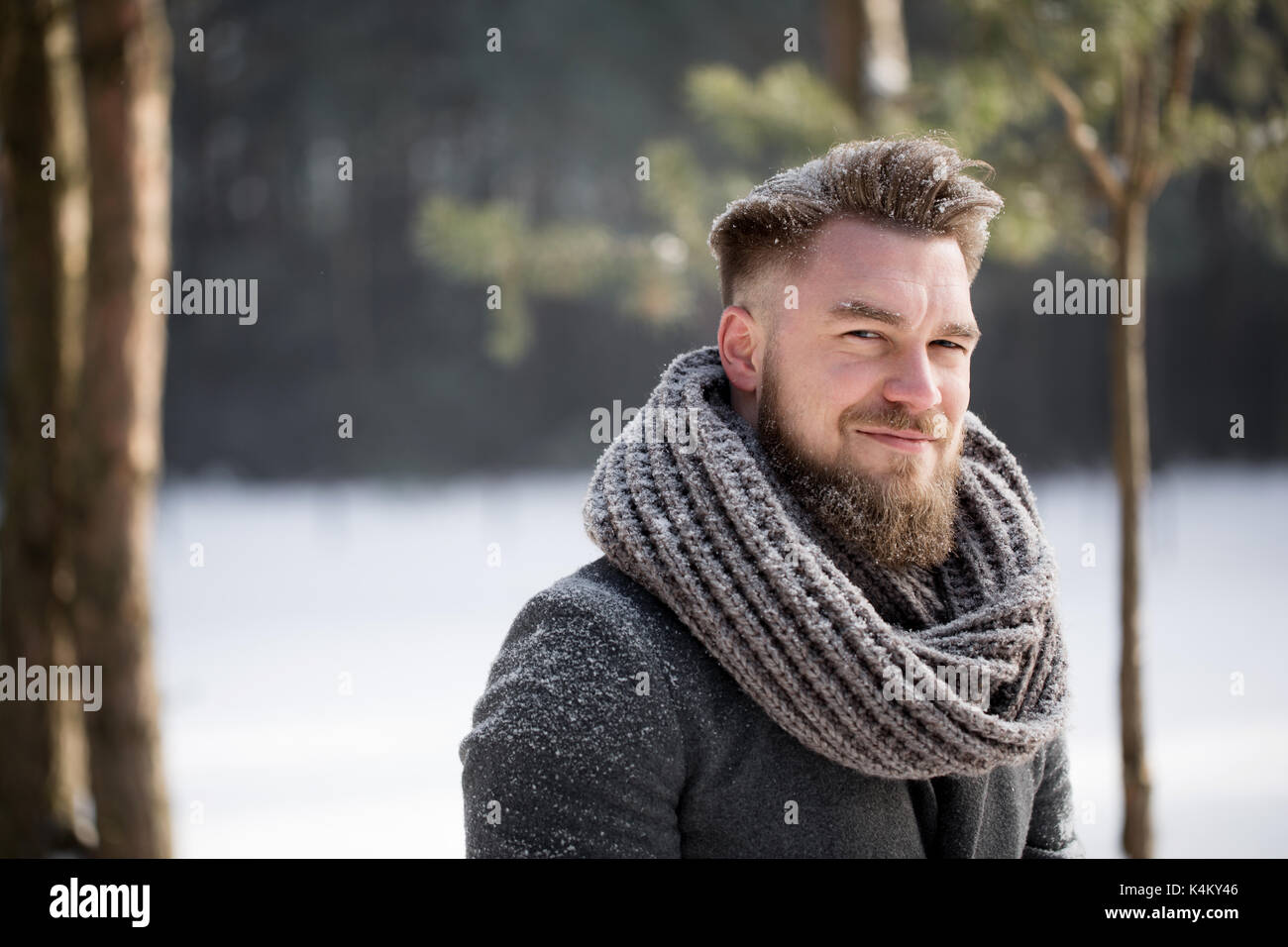 Man in winter clothes walking in snowy forest Stock Photo