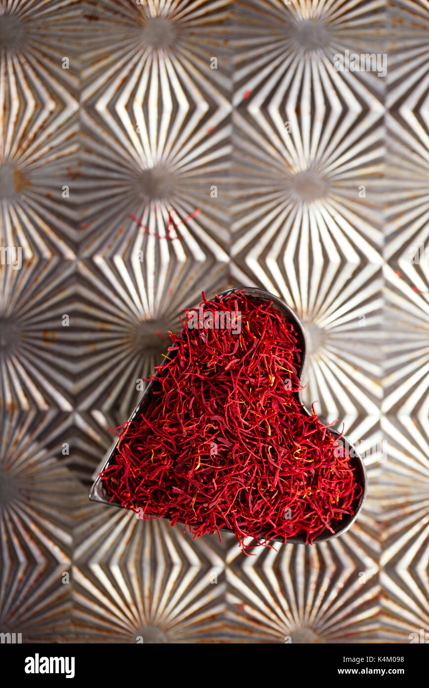 saffron space threads in vintage  heart shape tin  on metal background Stock Photo