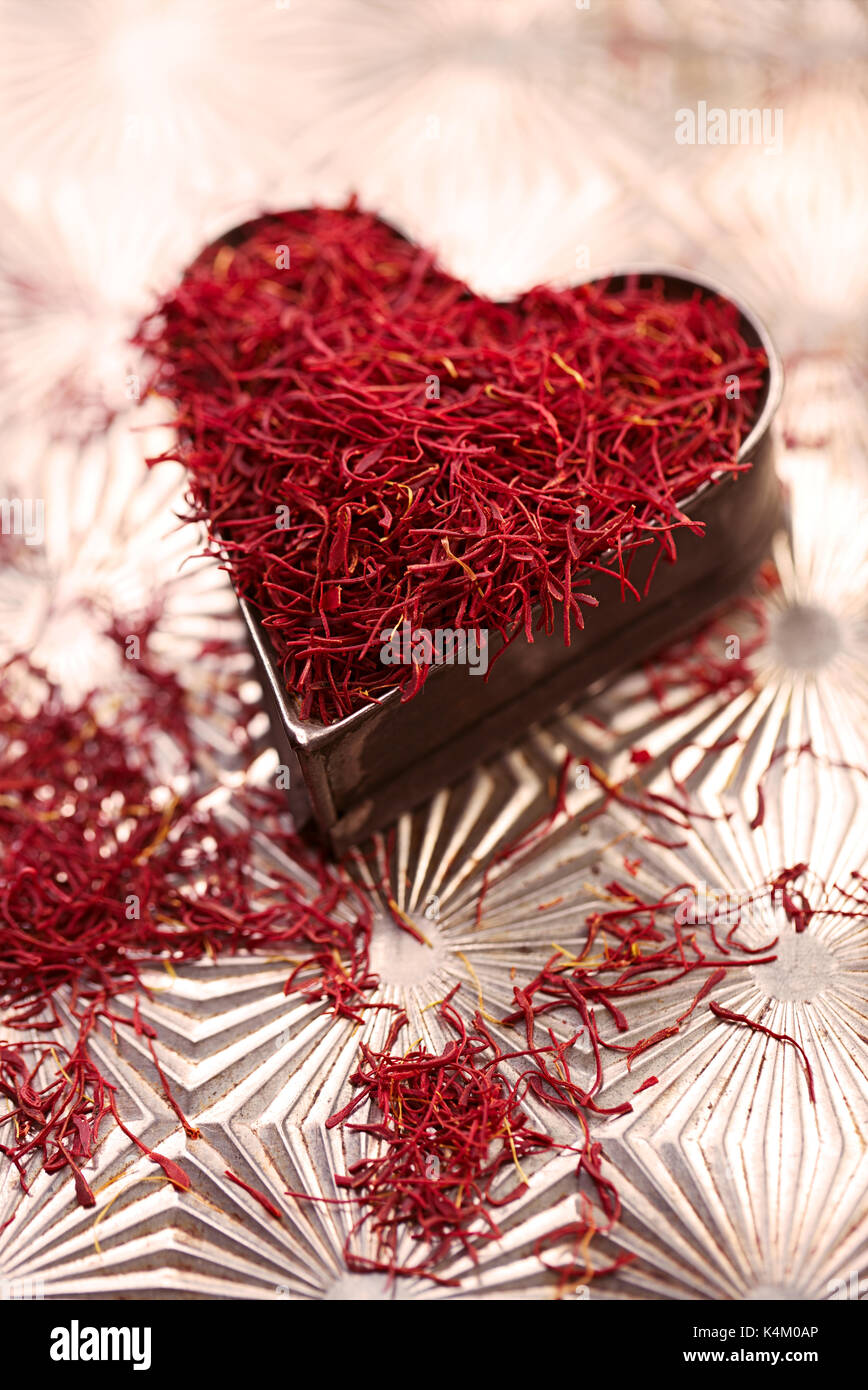 saffron space threads in vintage  heart shape tin  on metal background Stock Photo
