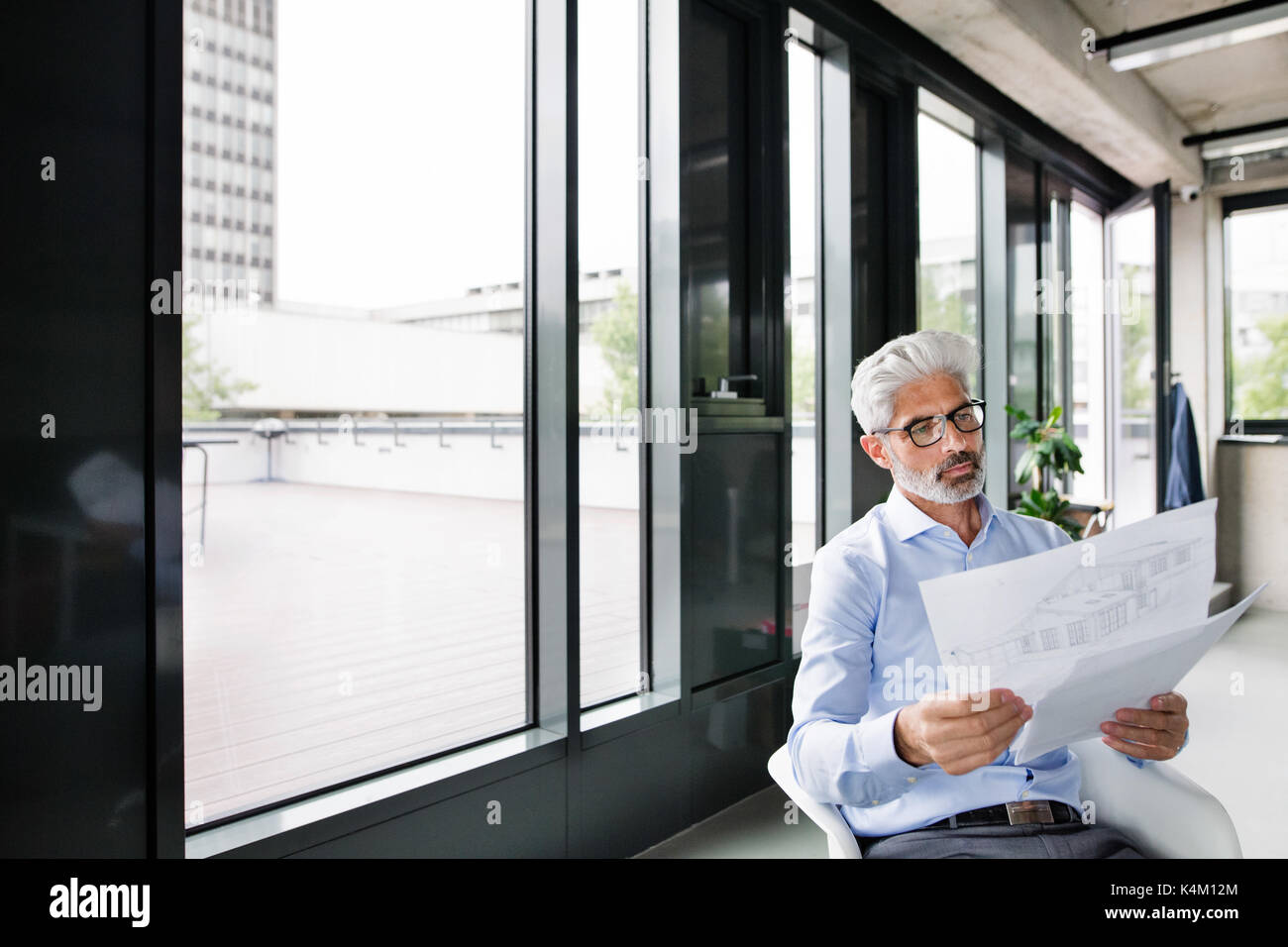 Mature businessman in blue shirt in the office. Stock Photo