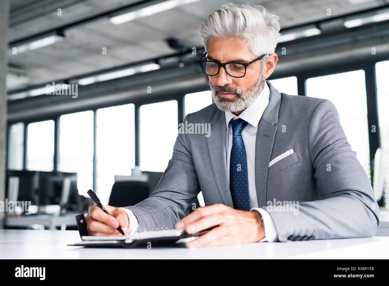 Mature businessman in gray suit in the office Stock Photo - Alamy