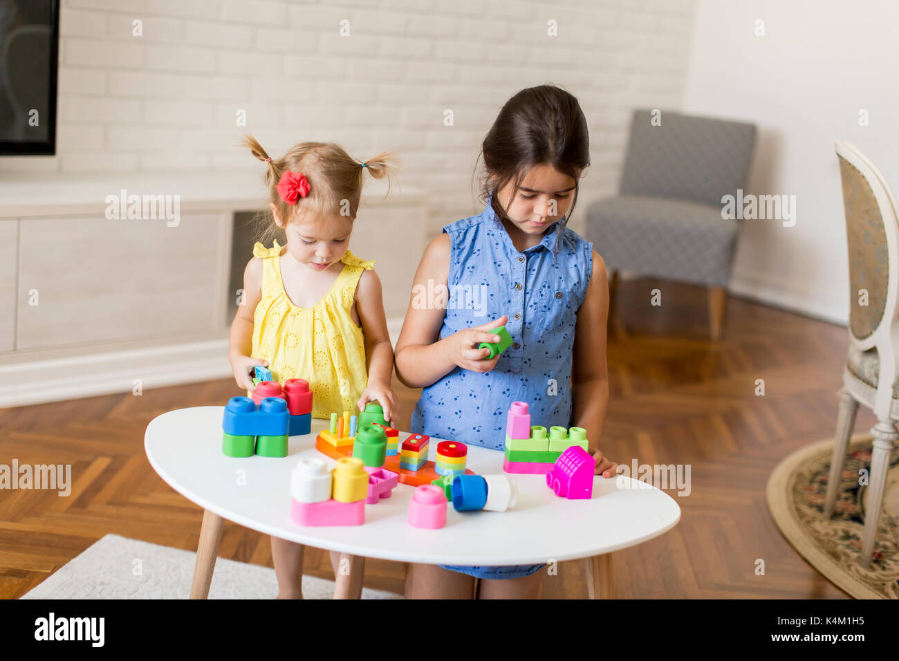 Two little girls playing with toys in the room at home Stock Photo - Alamy