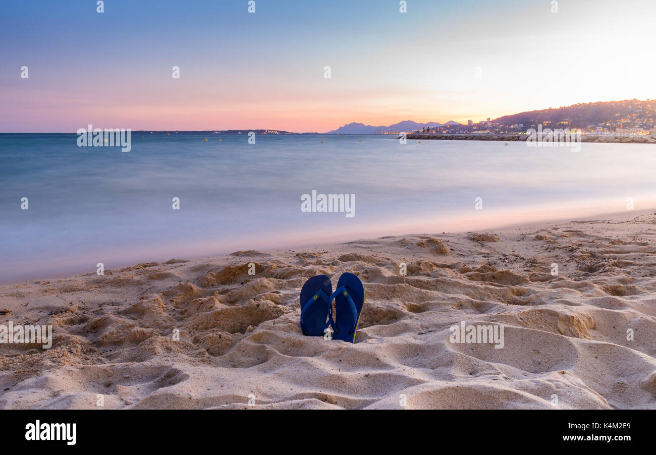 Flip flops on a sandy beach at sunset Stock Photo