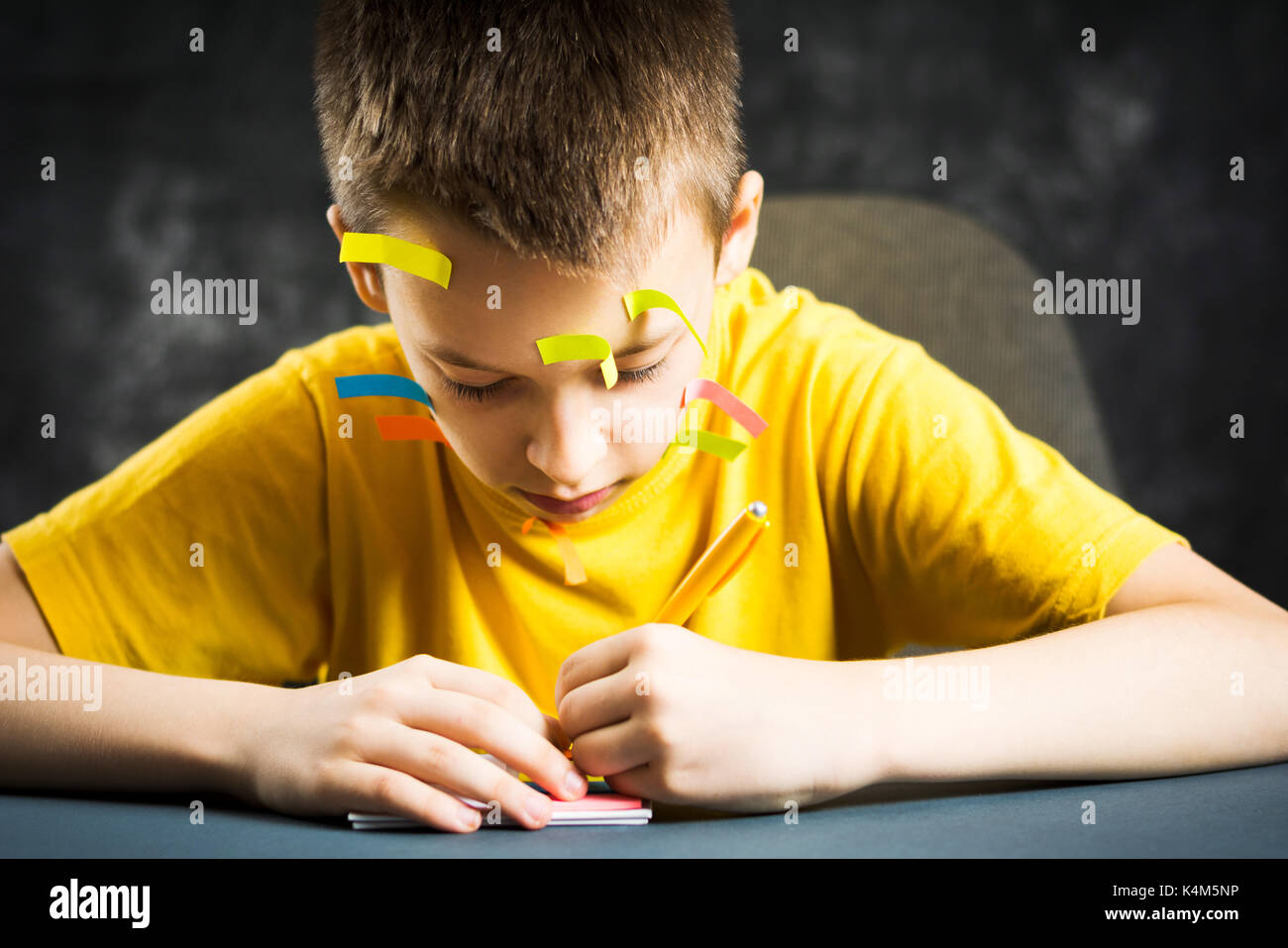 Teenage boy with his face covered in note stickers Stock Photo