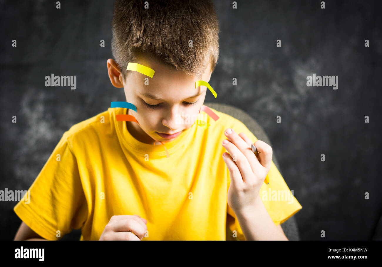 Teenage boy with his face covered in note stickers Stock Photo