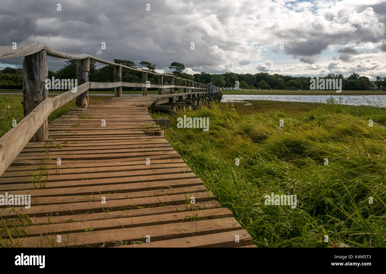 A Wooden footbridge over mudflats at high tide at Aberlady Bay local nature reserve, East Lothian coast, Scotland, UK Stock Photo