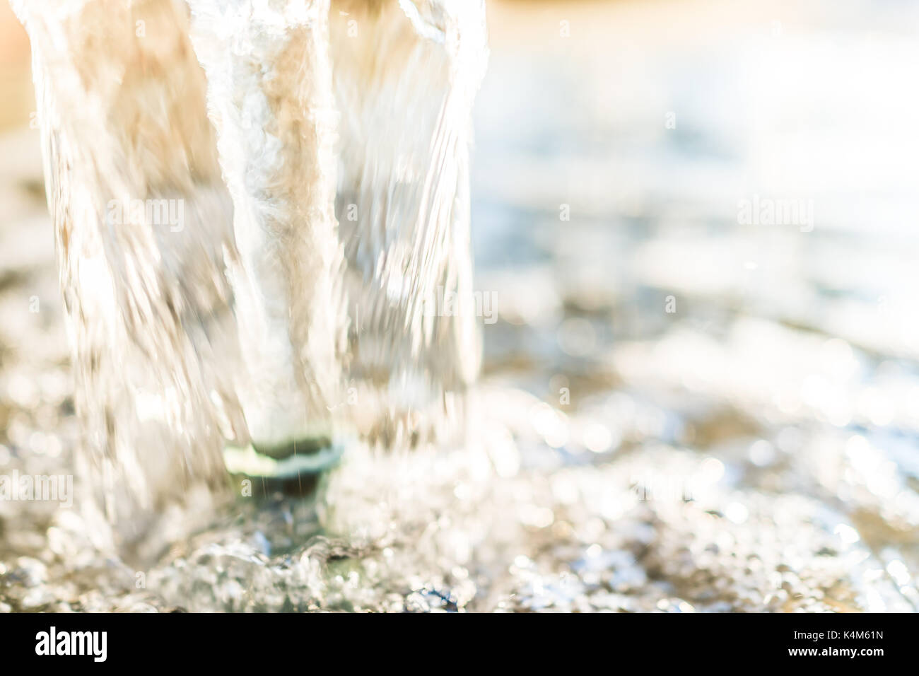 Detail macro close up of golden water fountain stream in park with