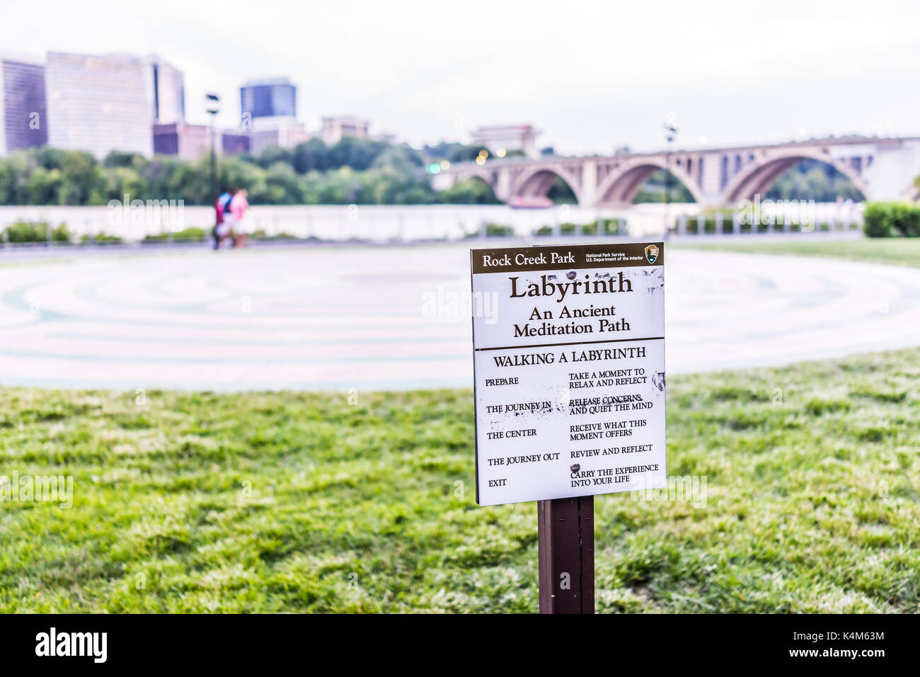 Washington DC, USA - August 4, 2017: Rock Creek Park Labyrinth sign by Potomac river, key bridge and Arlington cityscape in evening downtown Georgetow Stock Photo