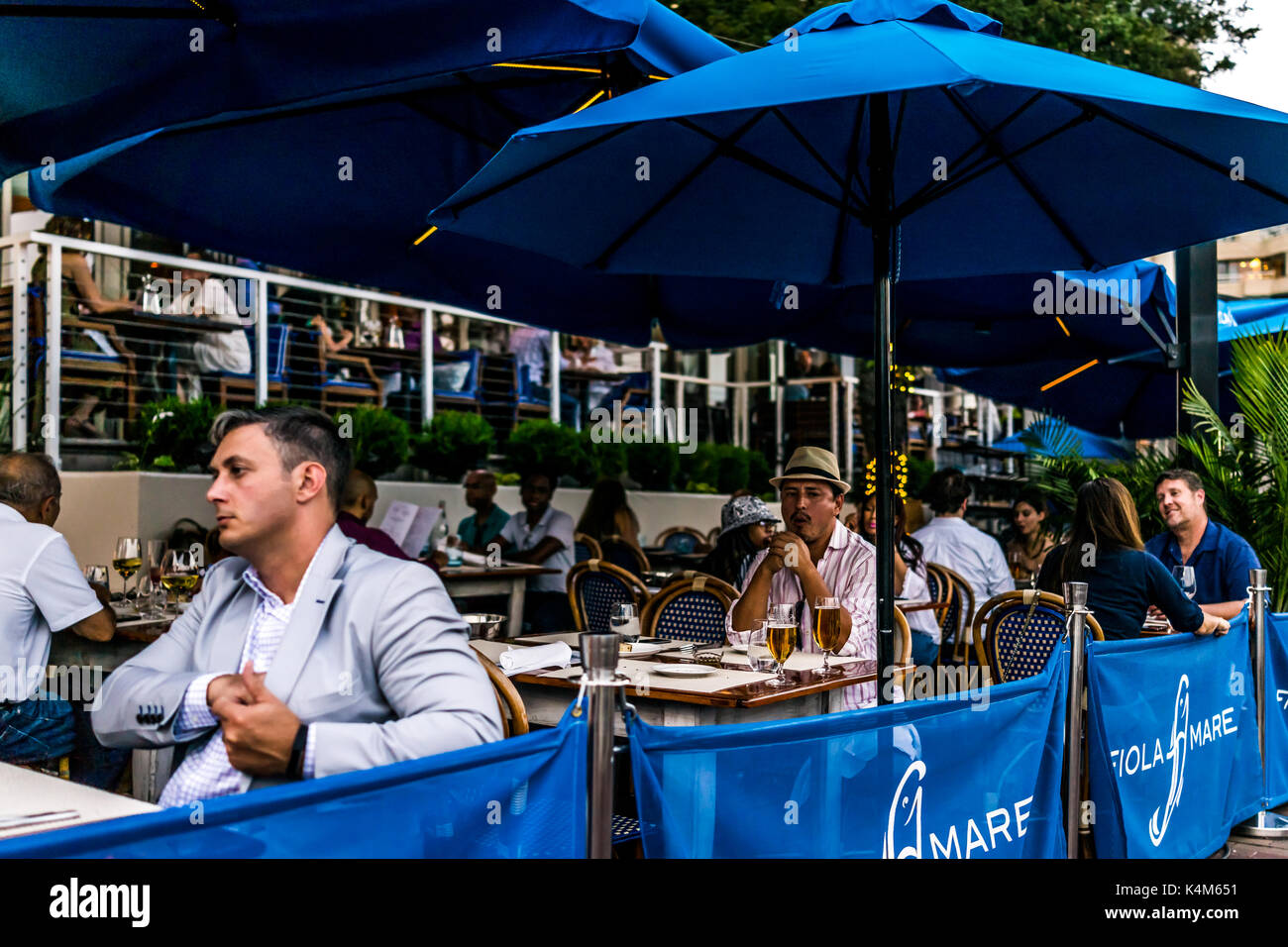 Washington DC, USA - August 4, 2017: People sitting in Georgetown restaurant on riverfront in evening called Fiola Mare Stock Photo