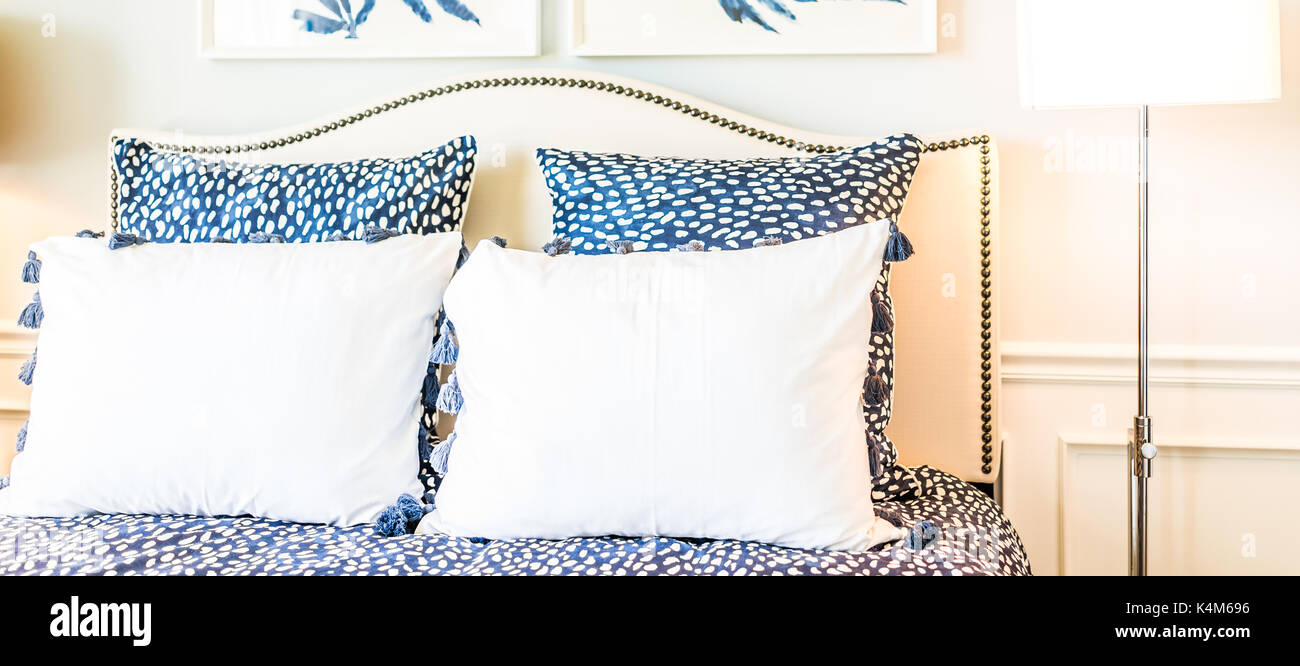 Closeup of new bed comforter with decorative pillows in bedroom in staging model home apartment or house Stock Photo