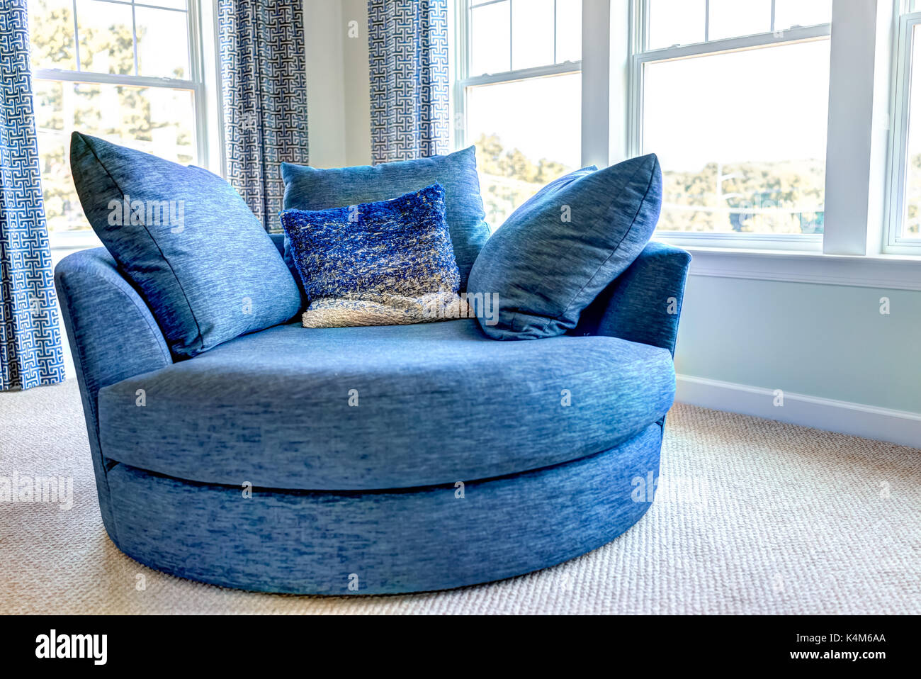 Closeup of new modern blue couch sofa by windows with natural light in home house or apartment