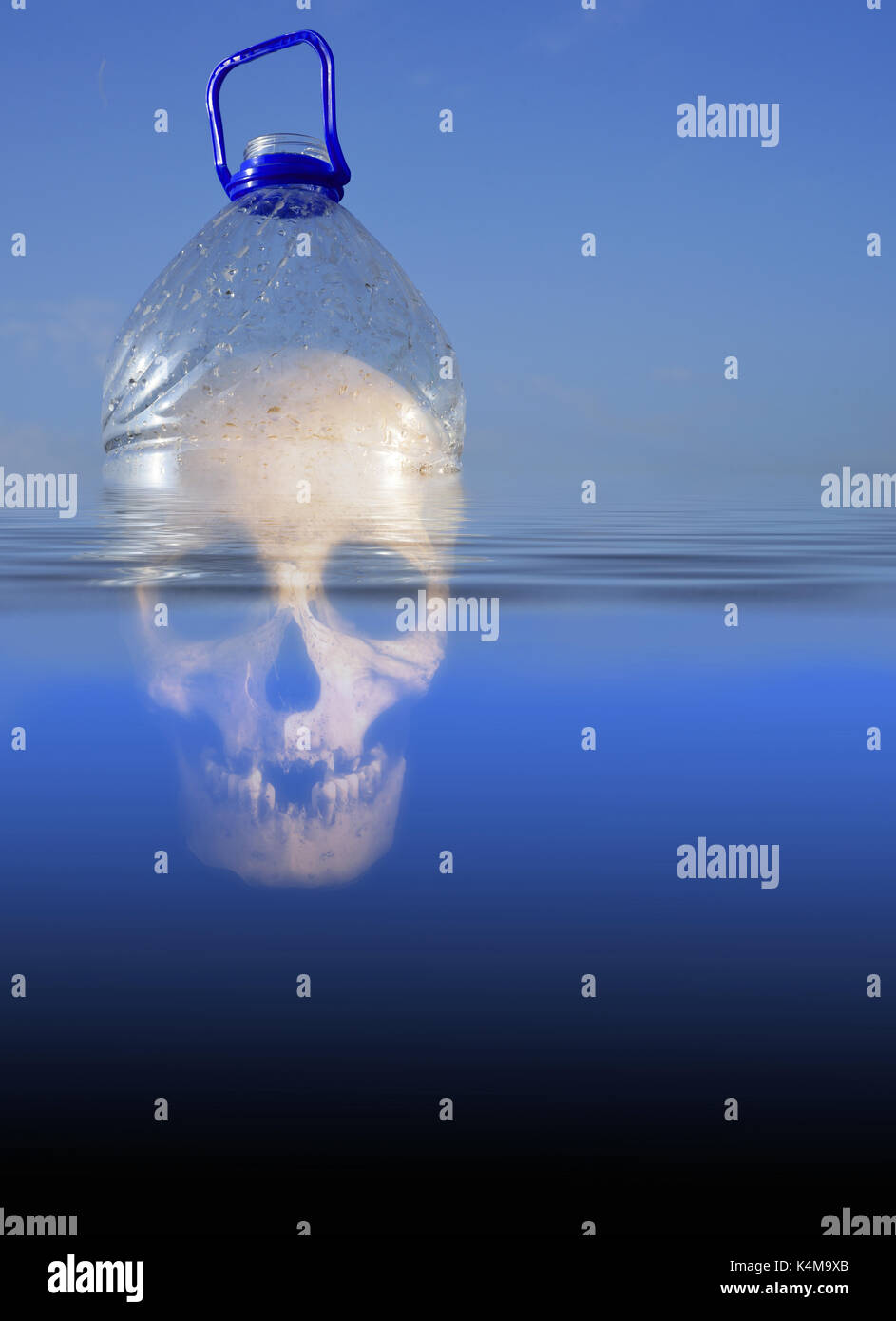 Pollution themed design of a plastic PET drinking container floating in sea water with a human skull submerged beneath the environment Stock Photo