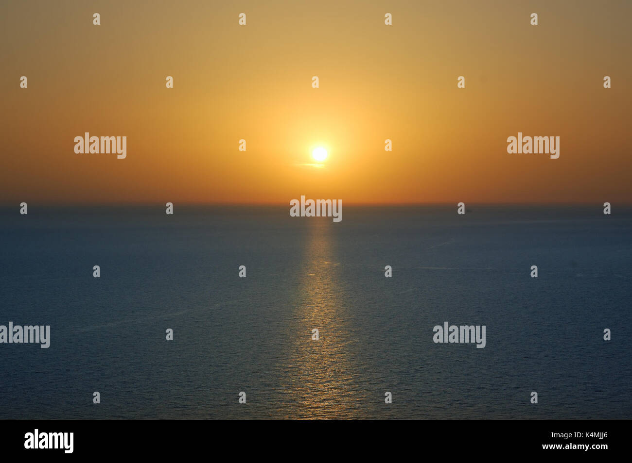 Sunset over water. Deep blue sea and orange colored sky background ...