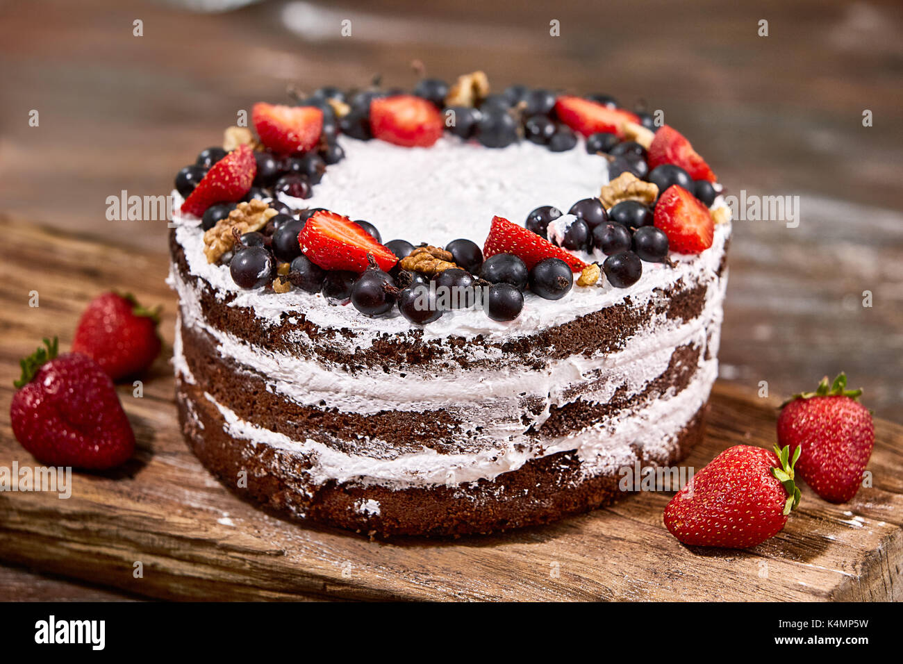 a cut of cake with whipped cream and strawberry fruits on wood table ...