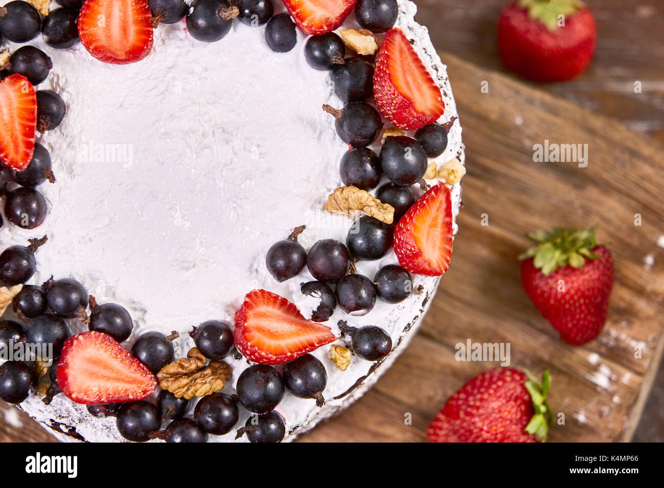 a cut of cake with whipped cream and strawberry fruits on wood table ...