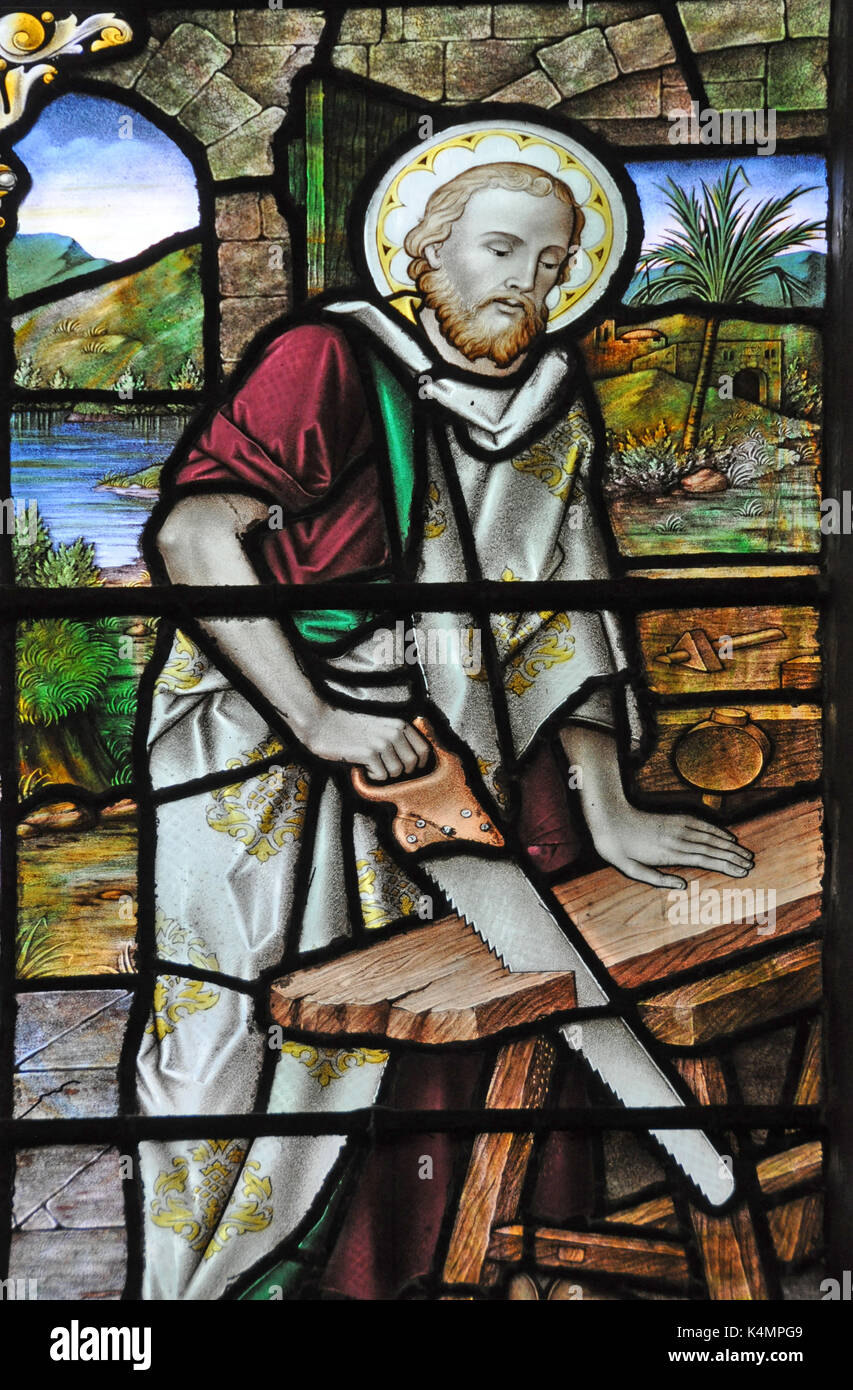 Joseph the Carpenter, Jesus'  father, sawing wood in a Victorian stained glass window in a catholic church in Fleetwood, Lancashire Stock Photo