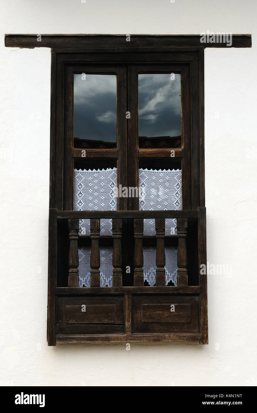 Colombia, Beautiful white villa with shingle roofs hidden behind walls in colonial Villa de Leyva. Old style window Stock Photo