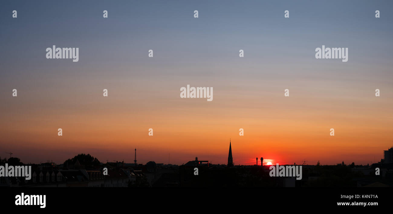 sunset sky over city - colorful sky panorama over rooftops Stock Photo