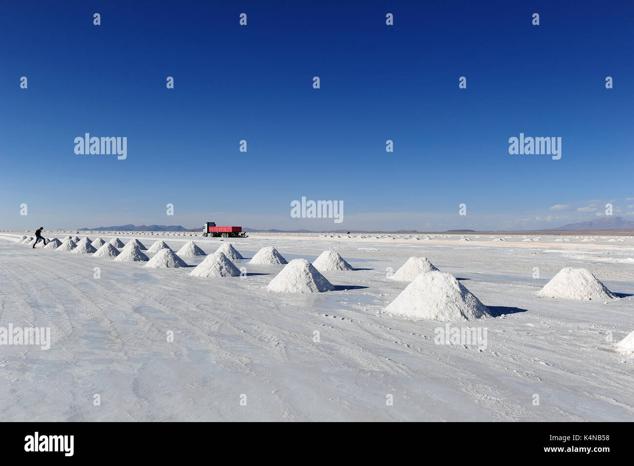 A truck near a series of salt cones in the salt flats in Uyuni, Bolivia Stock Photo